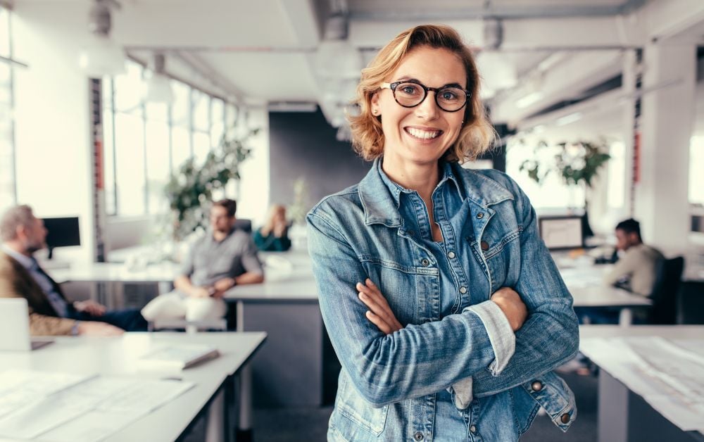 AdobeStock_170017144 ung glad kvinna i ett kontorslandskap Hubspot