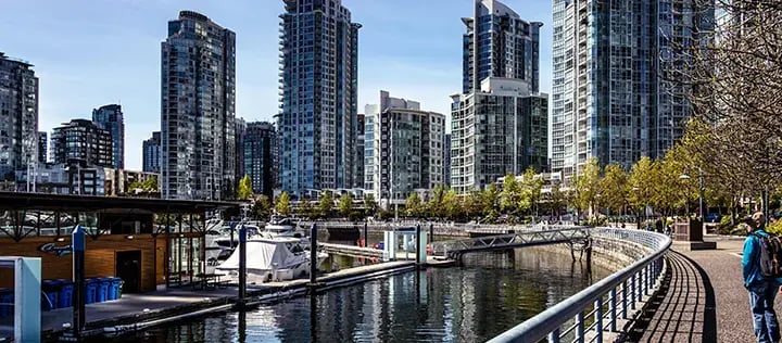 Stadsvy över Vancouver med moderna höghus, marina och promenadstråk längs vattnet