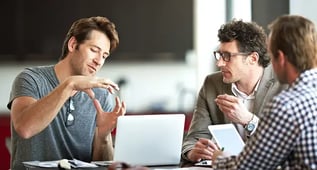 Personer i samtal under ett arbetsmöte vid en laptop