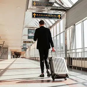 Resenär som går genom en flygplats med resväska