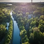 Vy över ett grönt landskap med vatten och träd